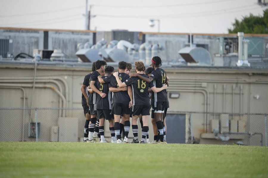 Figure 1a: A football team huddled together on the pitch: a group, because members interact, have defined roles and share a goal (compare the book's own Fig. 7.1 Picture A). Photo: Uwantsomegum / Wikimedia Commons / CC0.